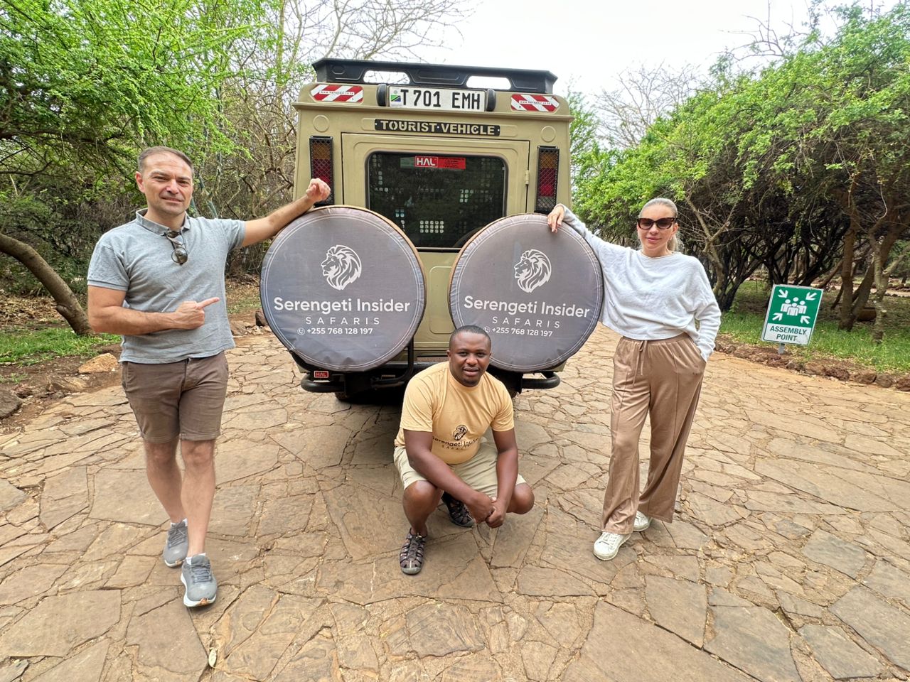 Tourists standing outside a vehicle at Farm of Dreams, Tanzania.